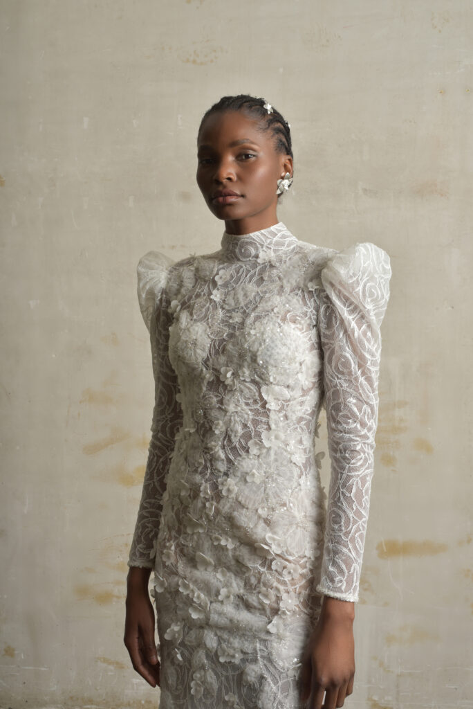 femme habillée d'une robe de mariée sirène glamour, avec des manches longues et un joli dos nu