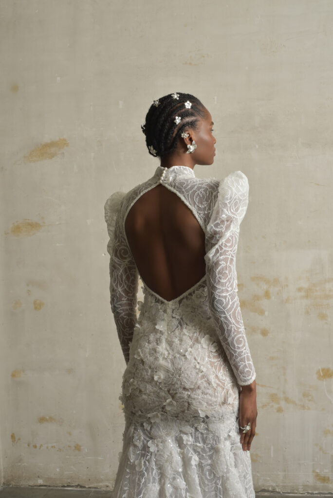 femme habillée d'une robe de mariée sirène glamour, avec des manches longues et un joli dos nu
