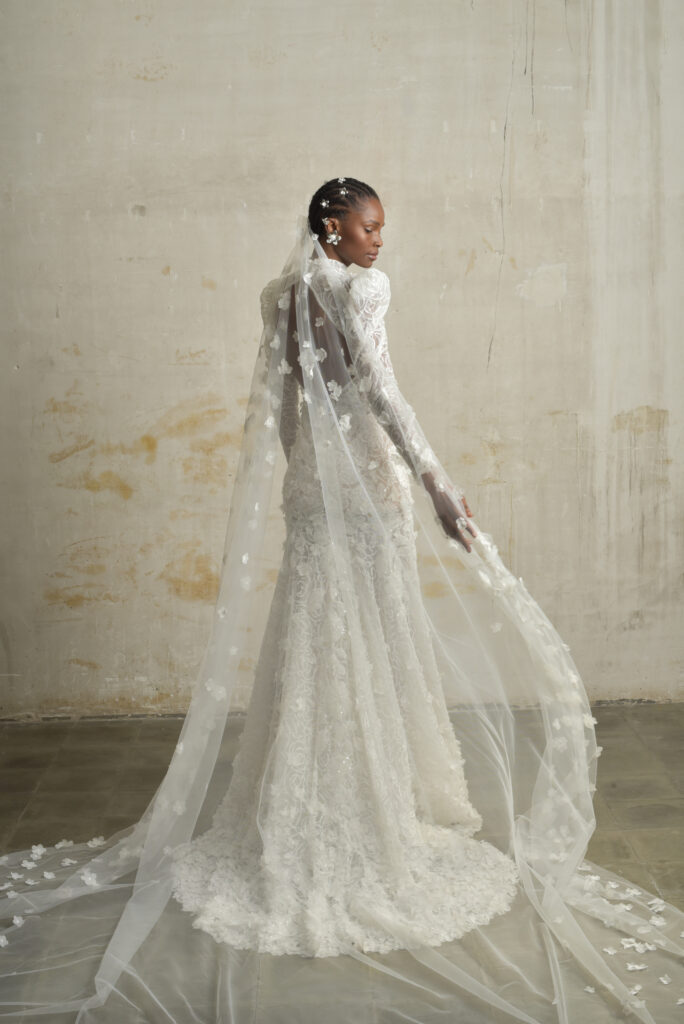 femme habillée d'une robe de mariée sirène glamour, avec des manches longues et un joli dos nu