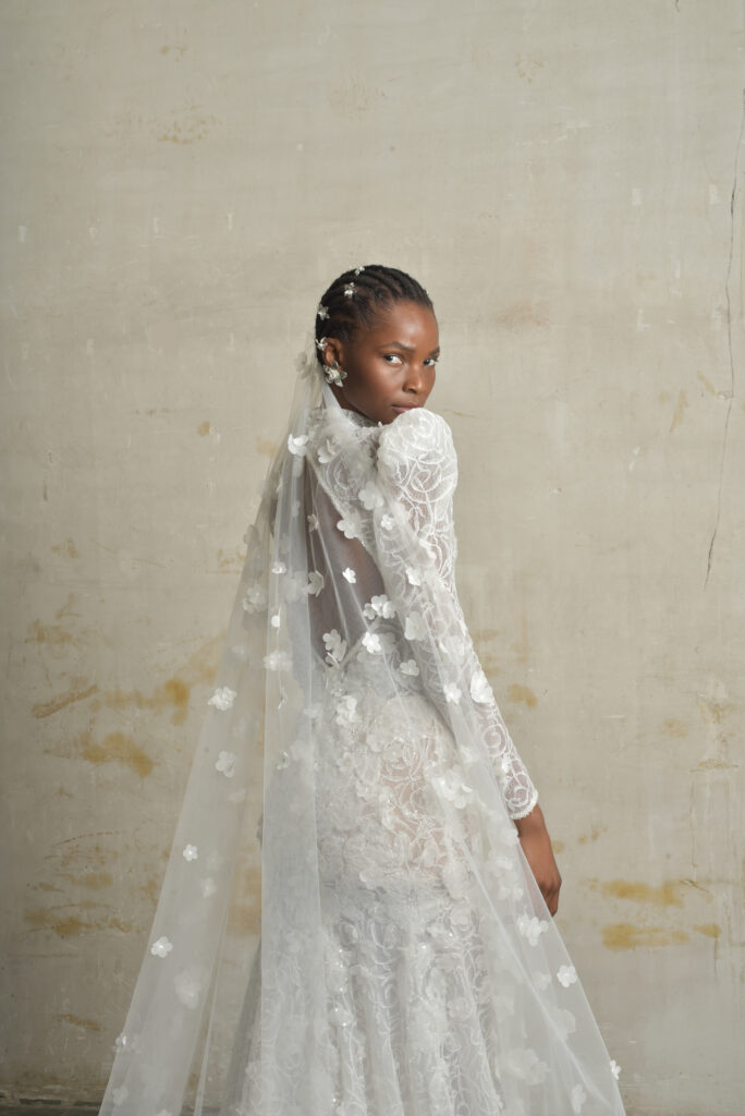 femme habillée d'une robe de mariée sirène glamour, avec des manches longues et un joli dos nu