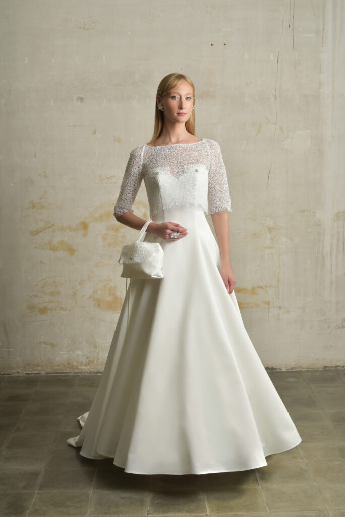 femme habillée d'une robe de mariée princesse élégante, agrémentée d'un joli top de mariée et d'un sac à main