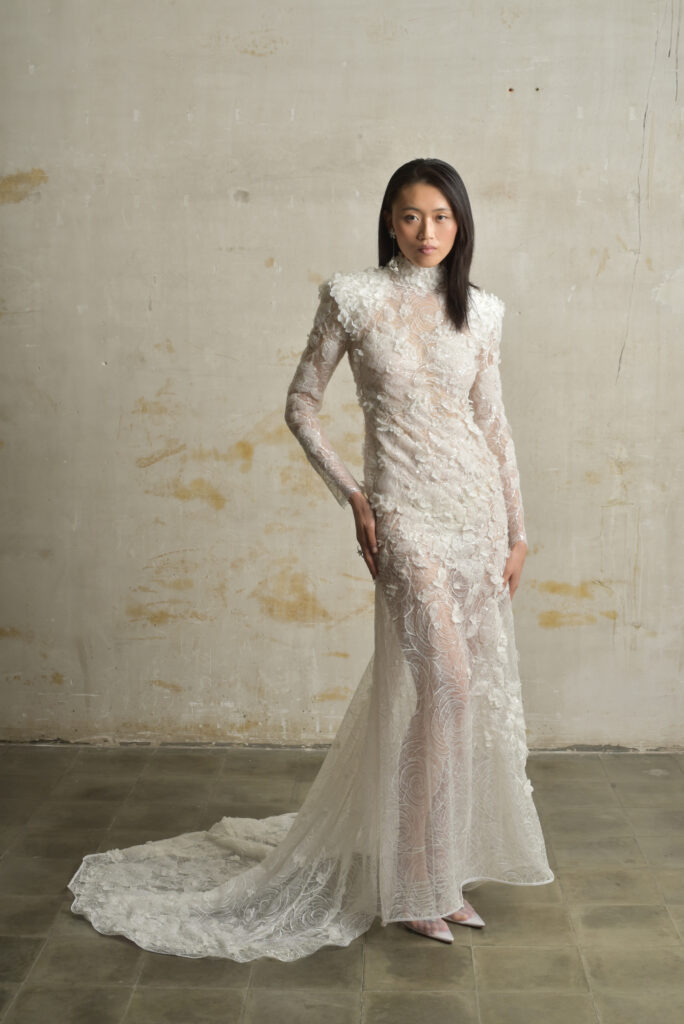 femme habillée d'une robe de mariée sirène glamour, avec une traîne et des manches longues