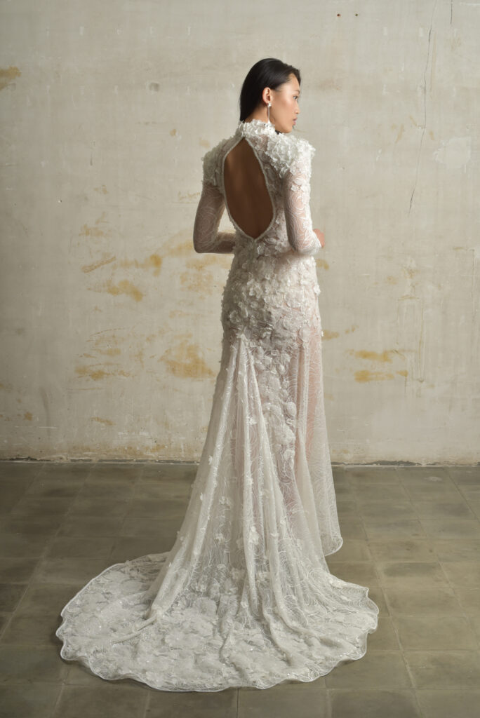 femme habillée d'une robe de mariée sirène glamour, avec une traîne et des manches longues