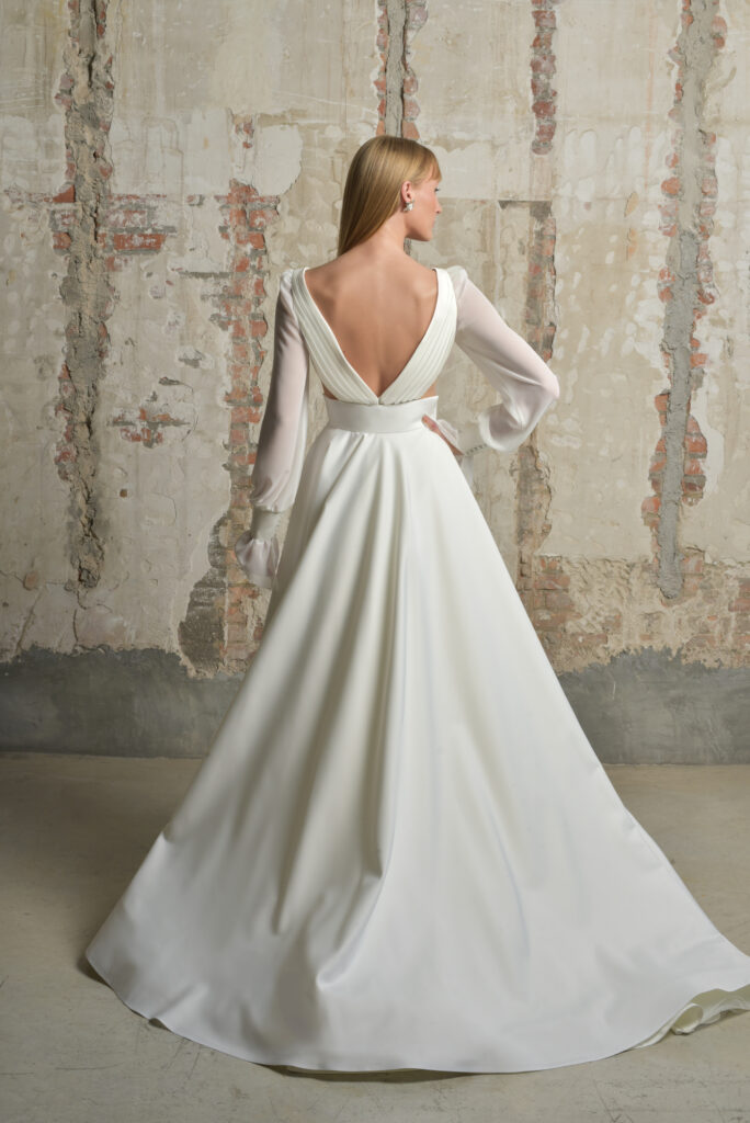 femme dans une robe de mariée épurée et fluide avec des manches longues amovibles
