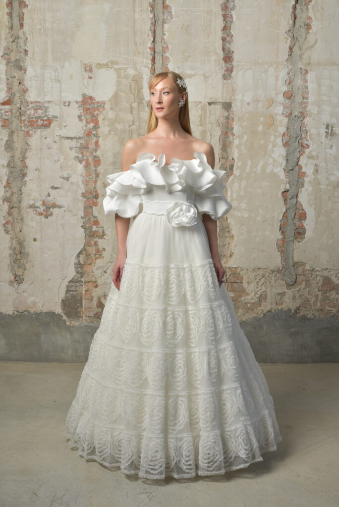 femme habillée d'une robe de mariée originale avec une col à volant et une jupe volumineuse à motifs