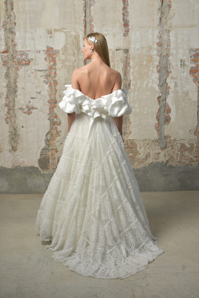 femme habillée d'une robe de mariée originale avec une col à volant et une jupe volumineuse à motifs