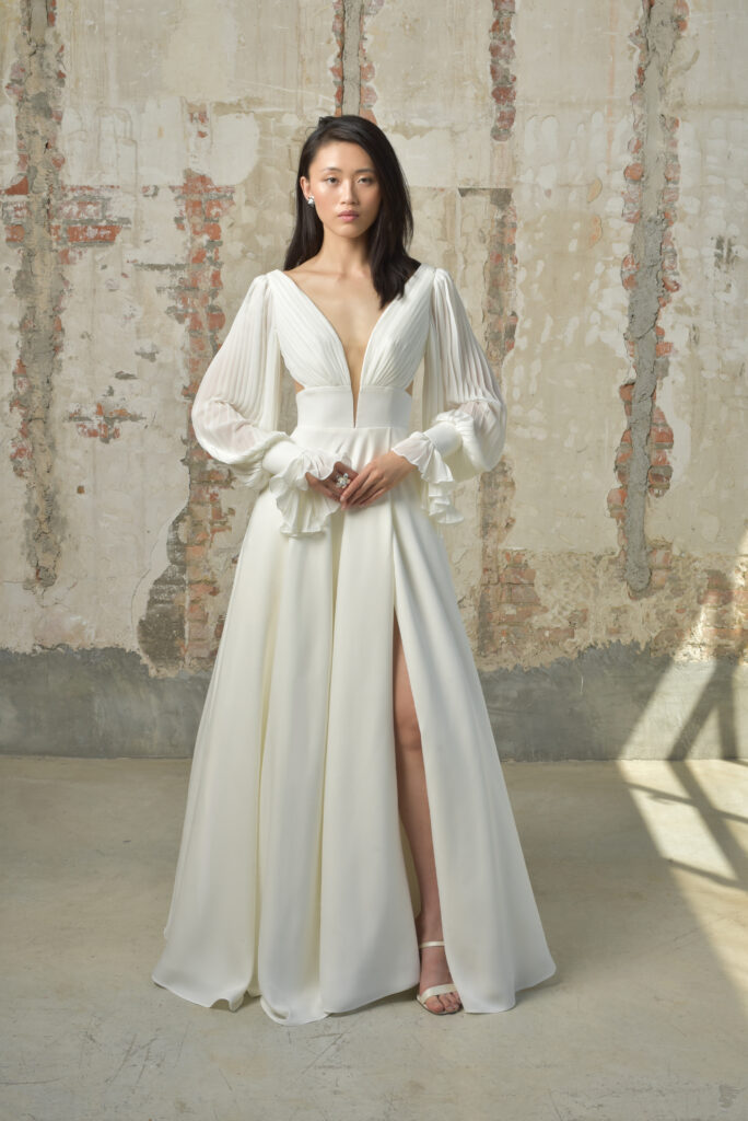 femme dans une robe de mariée épurée et fluide avec des manches longues amovibles