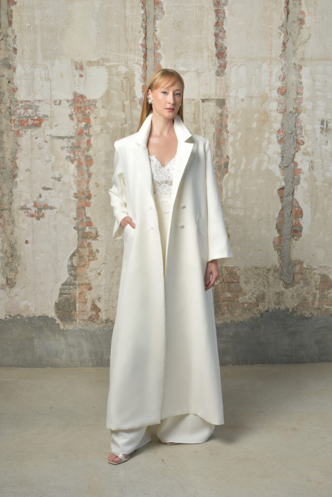 femme dans une tenue de cérémonie avec un manteau long et un pantalon blanc