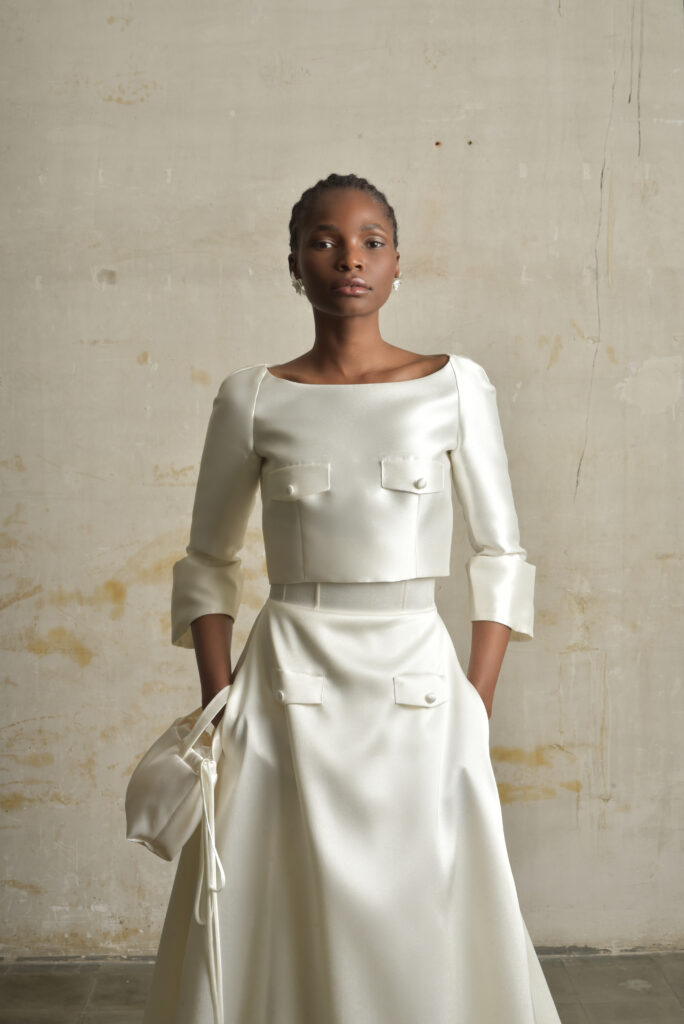 femme habillée d'une tenue de mariée raffinée composée d'un top court et une jupe longues avec des détails de poches