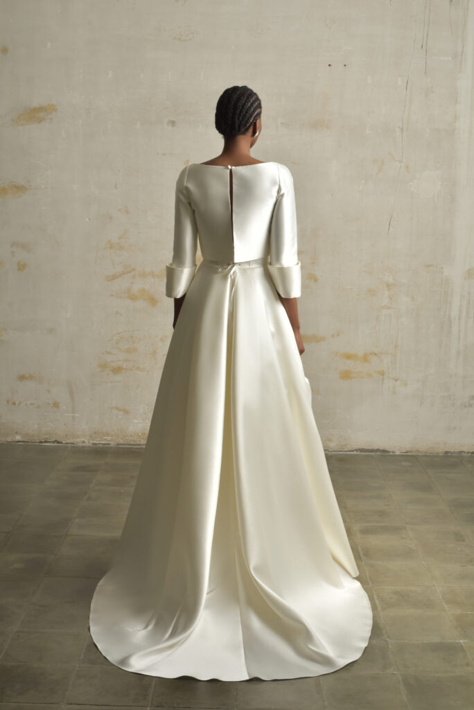 femme habillée d'une tenue de mariée raffinée composée d'un top court et une jupe longues avec des détails de poches