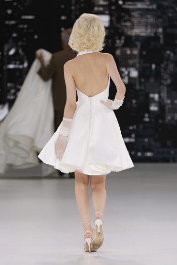 femme dans une robe de mariée à bretelles sur un podium de défilé