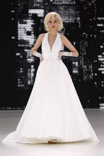 femme dans une robe de mariée à bretelles sur un podium de défilé