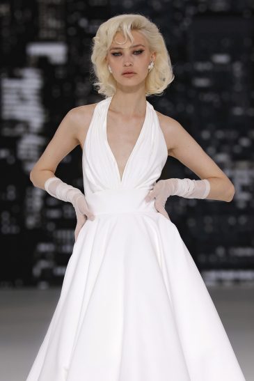 femme dans une robe de mariée à bretelles sur un podium de défilé