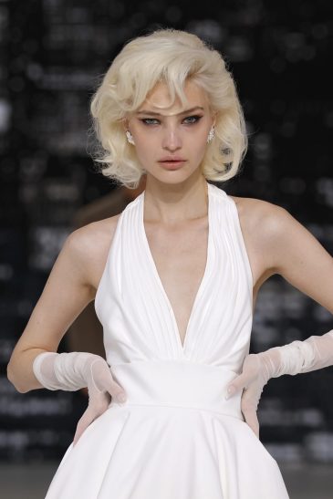 femme dans une robe de mariée à bretelles sur un podium de défilé