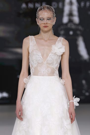 femme dans une robe de mariée à bretelles sur un podium de défilé