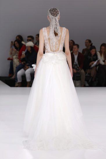 femme dans une robe de mariée à bretelles sur un podium de défilé