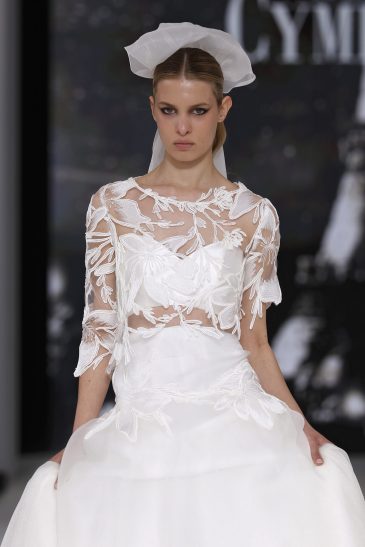 femme dans une robe de mariée avec un top en dentelle et une jupe sur un podium de défilé