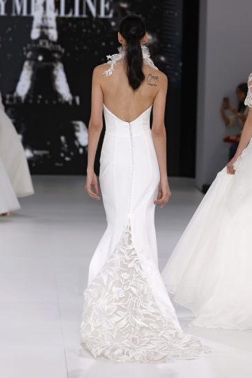 femme dans une robe de mariée sirène sur un podium de défilé