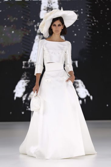 femme dans une robe de mariée avec un top et une jupe sur un podium de défilé