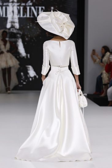 femme dans une robe de mariée avec un top et une jupe sur un podium de défilé