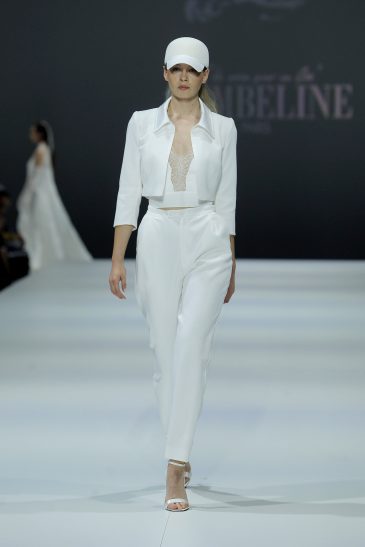 femme dans un ensemble de mariée veste, top et pantalon sur un podium de défilé