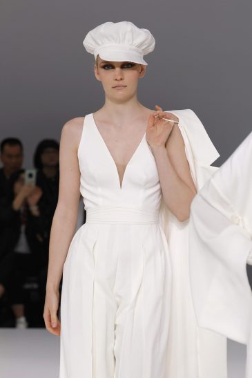 femme dans une combinaison de mariage sur un podium à un défilé