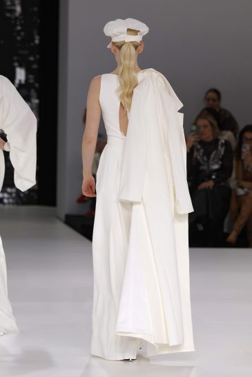 femme dans une combinaison de mariage sur un podium à un défilé