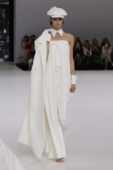 femme dans une combinaison de mariage sur un podium à un défilé