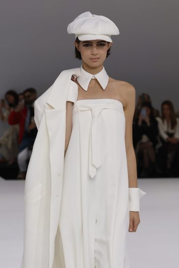 femme dans une combinaison de mariage sur un podium à un défilé