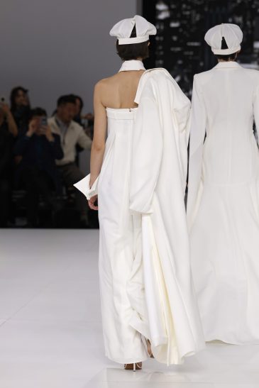 femme dans une combinaison de mariage sur un podium à un défilé