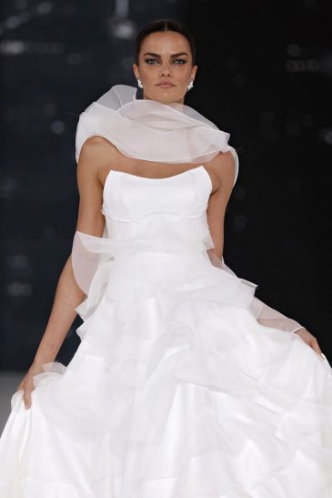 femme dans une robe de mariée à volants sur un podium de défilé
