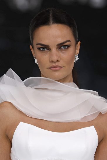 femme dans une robe de mariée à volants sur un podium de défilé