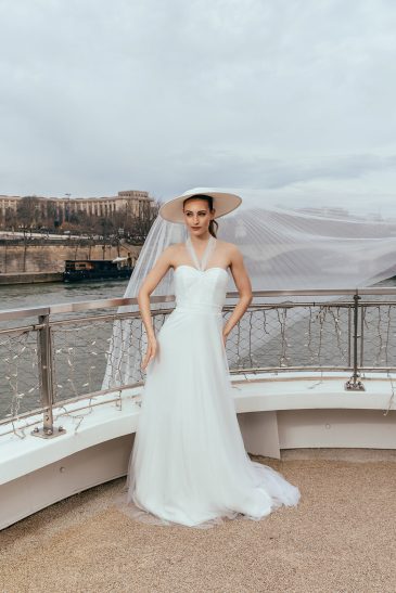 femme dans une robe de mariée glamour avec un chapeau à Paris