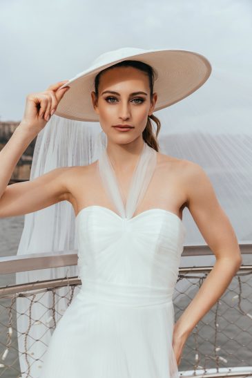 femme dans une robe de mariée glamour avec un chapeau à Paris