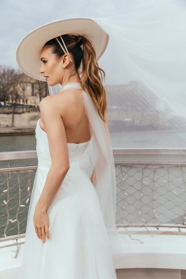 femme dans une robe de mariée glamour avec un chapeau à Paris