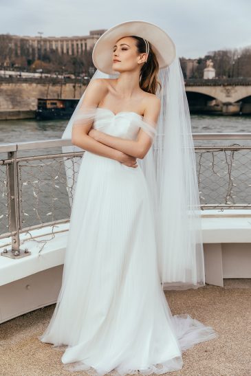 femme dans une robe de mariée glamour avec un chapeau à Paris