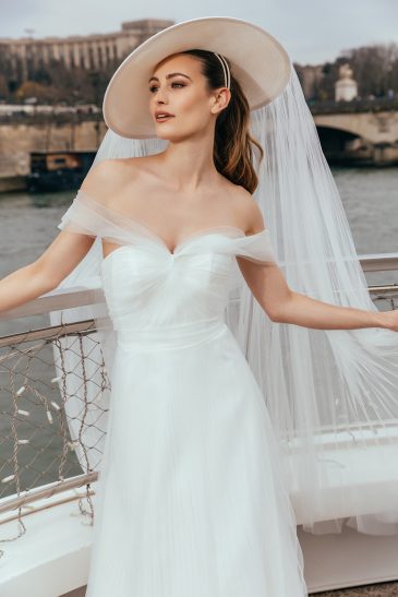 femme dans une robe de mariée glamour avec un chapeau à Paris