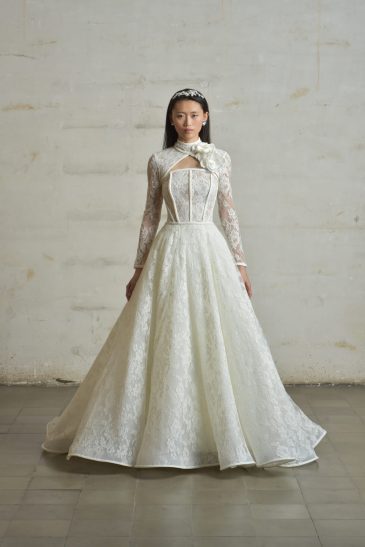 femme en robe de mariée princesse en dentelle de Calais-Caudry avec un col à manche amovible