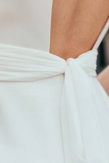 détail du dos de la ceinture de la robe de mariée portée par une femme