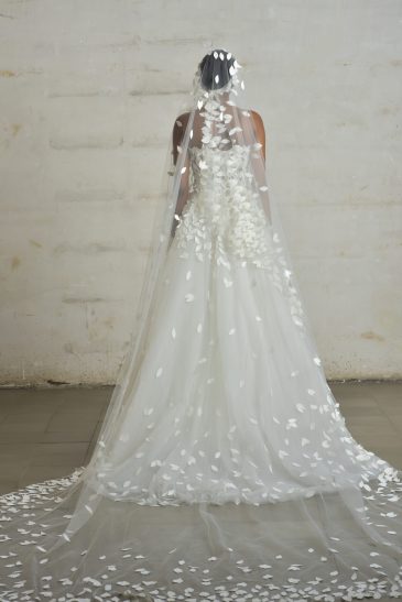 femme habillée en robe de mariée princesse en matière façonnée avec un voile