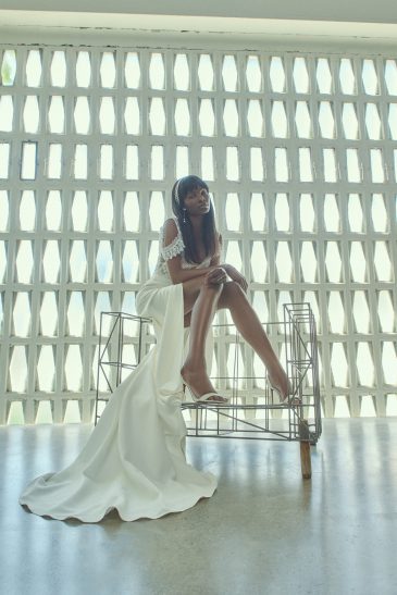 femme assise habillée d'une robe de mariée bohème aux détails élégants en dentelle