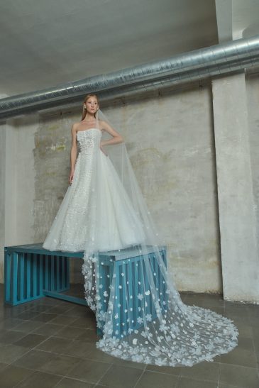 femme habillée d'une robe de mariée princesse glamour avec un voile long en traîne aux motifs à fleurs