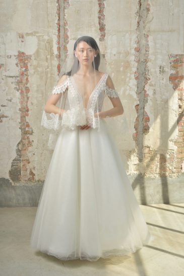 femme dans une robe de mariée princesse élégante avec un joli voile aux finitions en dentelles