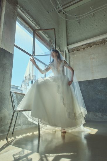 femme dans une robe de mariée princesse élégante avec un joli voile aux finitions en dentelles