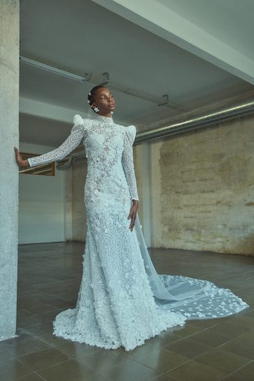 femme habillée d'une robe de mariée sirène glamour, avec une traîne et des manches longues