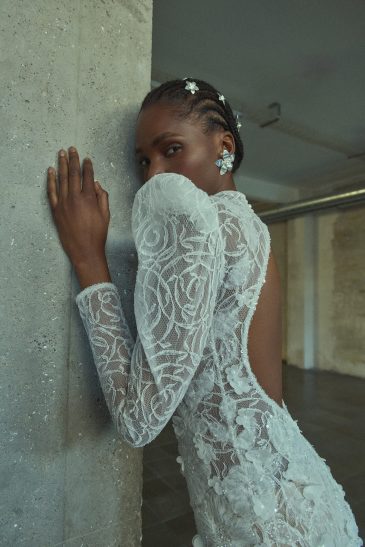 femme habillée d'une robe de mariée sirène glamour, avec des manches longues et un joli dos nu