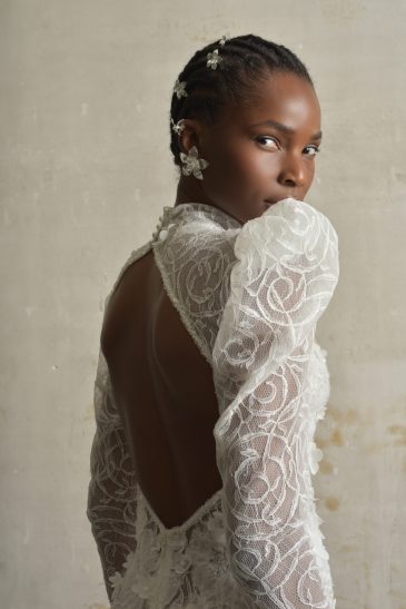 femme habillée d'une robe de mariée sirène glamour, avec des manches longues et un joli dos nu