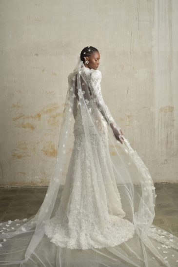 femme habillée d'une robe de mariée sirène glamour, avec des manches longues et un joli dos nu