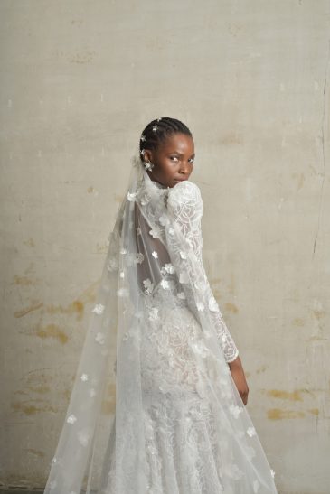 femme habillée d'une robe de mariée sirène glamour, avec des manches longues et un joli dos nu