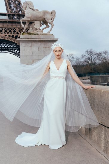 femme dans une robe de mariée sirène glamour avec un voile plissé à Paris